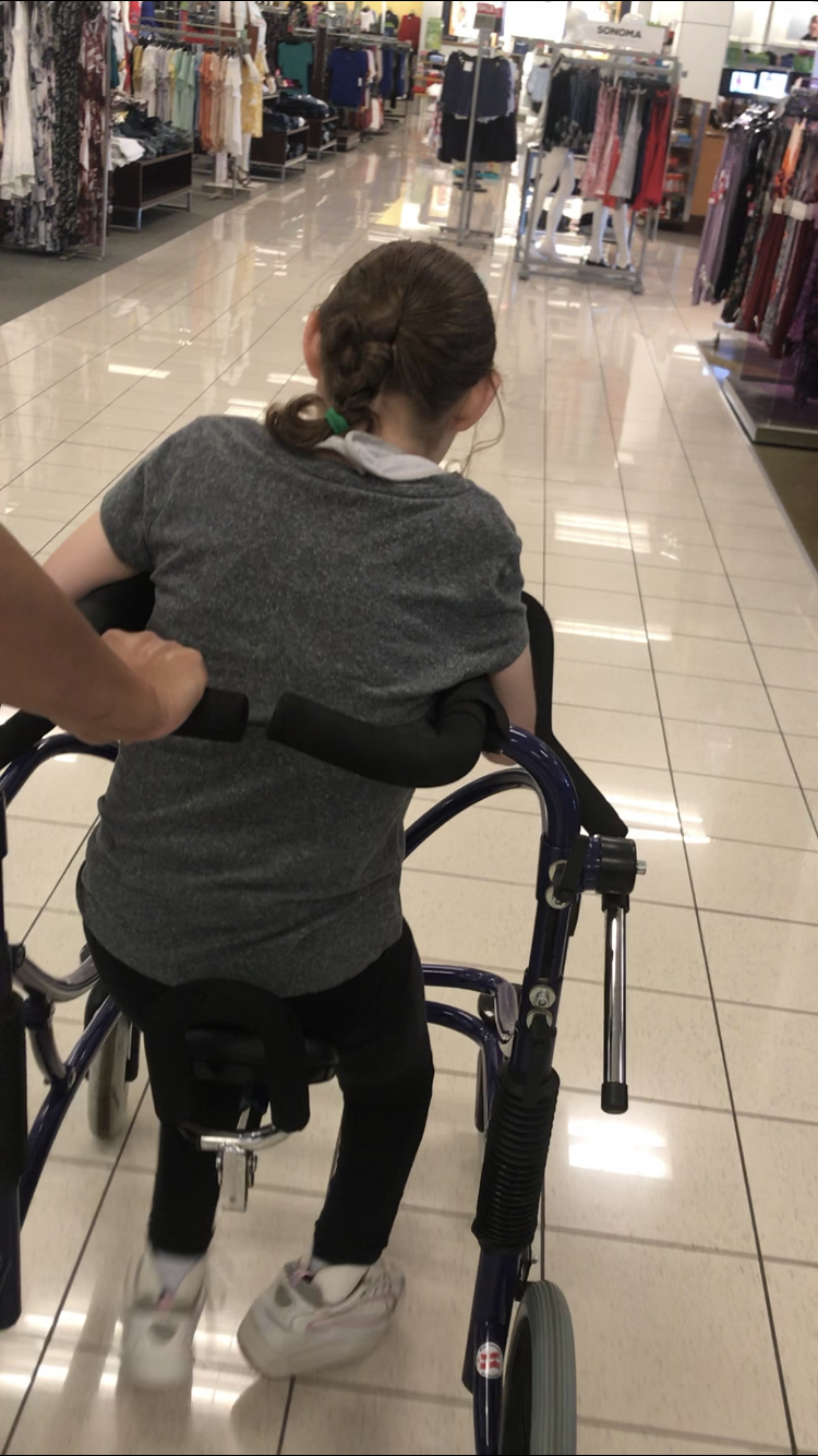 Kyia walking in her walker through Kohl’s.