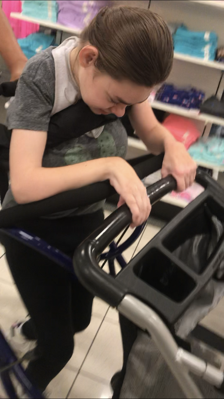 Kyia pushing the shopping cart while smiling.